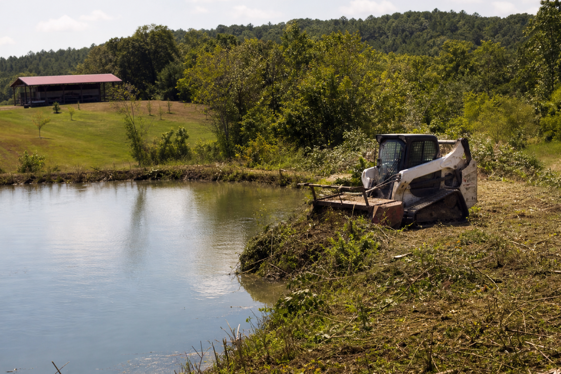 Farm pond with overgrown banks being cleared