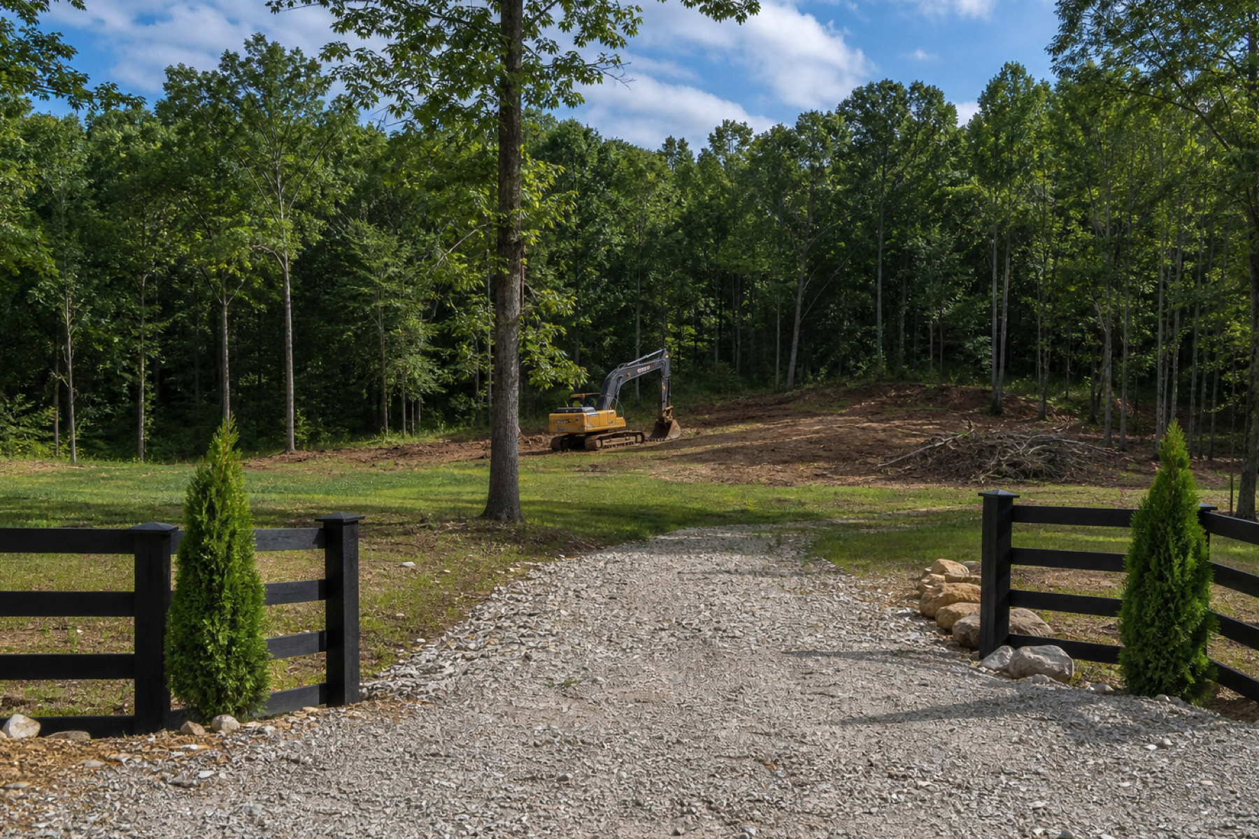 Marked rural property entrance and wooded work area being evaluated for land clearing